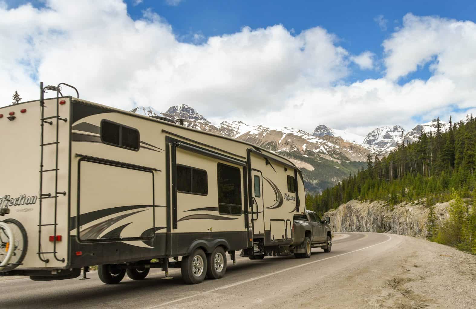 Fifth wheel travel trailer being towed in mountains