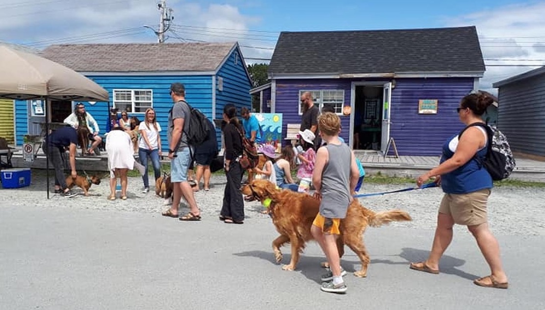 Fisherman's Cove Heritage Center with leashed dogs and families walking enjoying the quaint village/